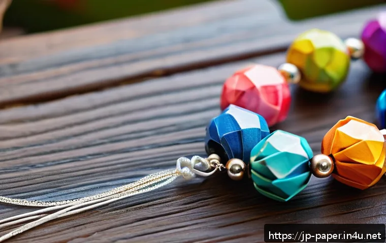 종이 비즈 만들기 - A close-up shot of handmade paper bead jewelry crafted from glossy wrapping paper, showcasing triang...